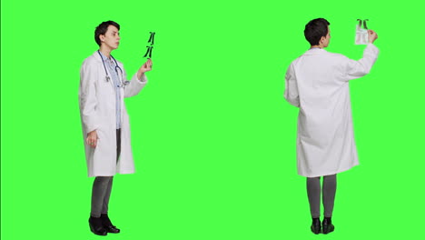 General-practitioner-examining-radiography-scan-against-greenscreen-backdrop
